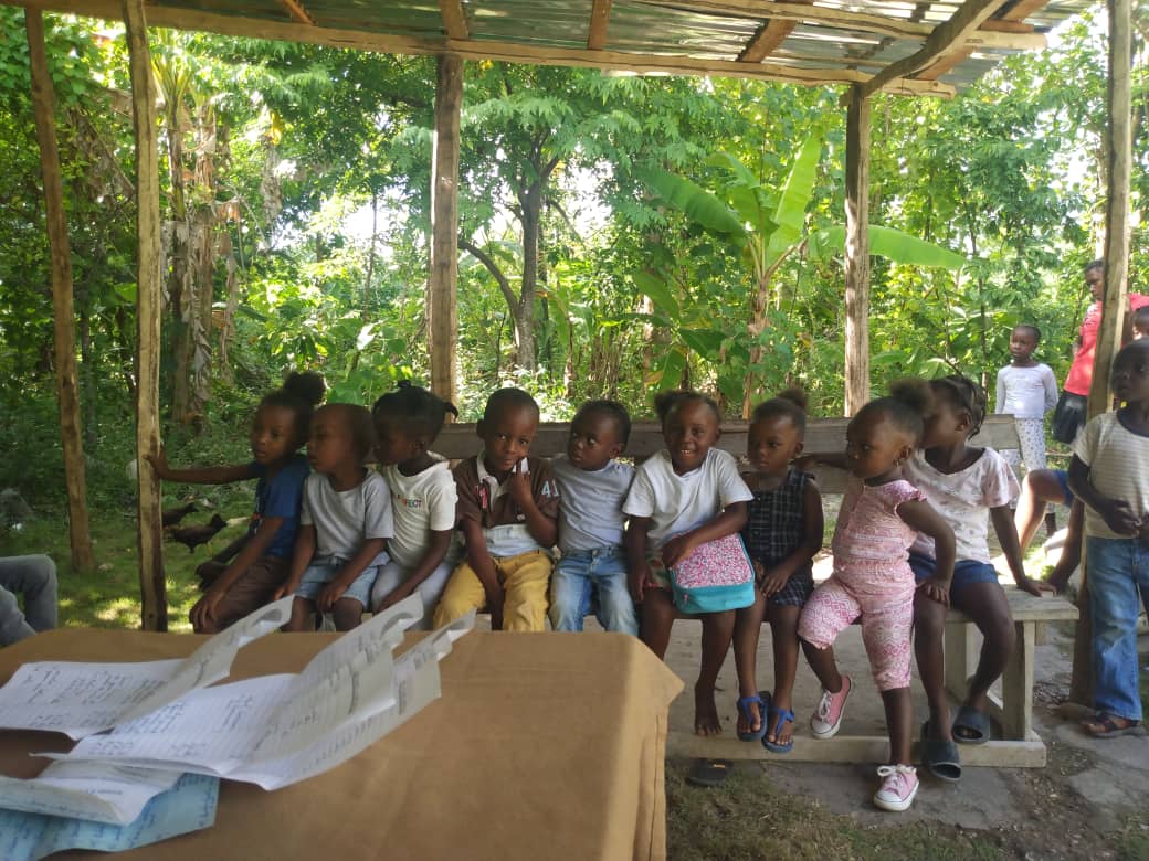 Preschoolers seated on a wooden bench